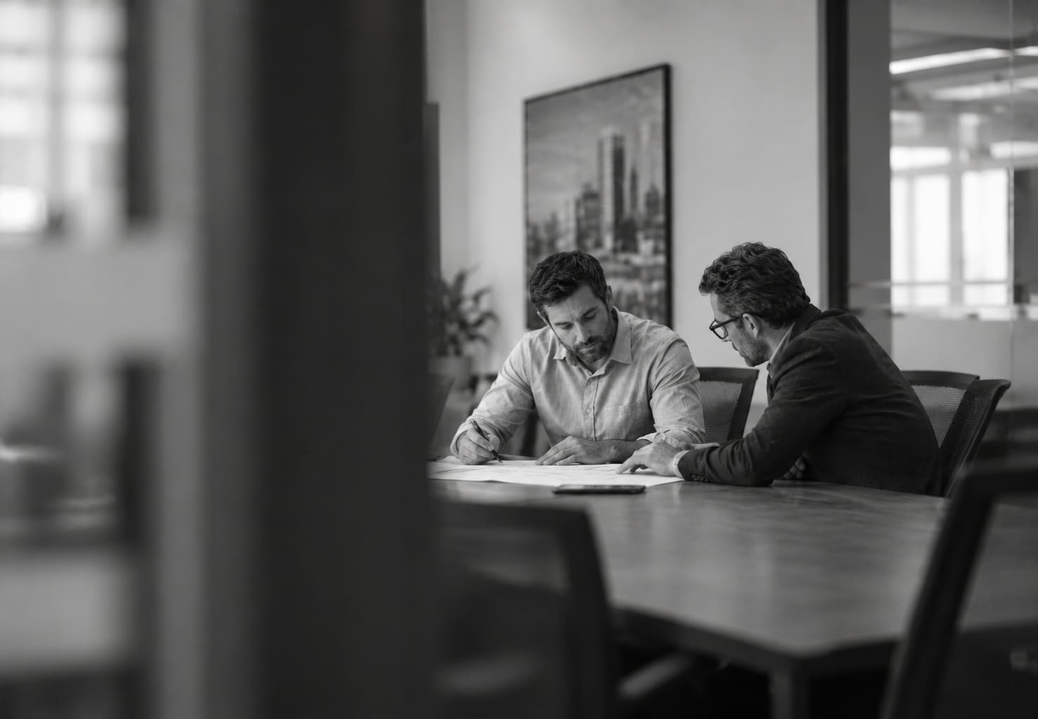 Two advisors at a meeting table, reviewing documents
